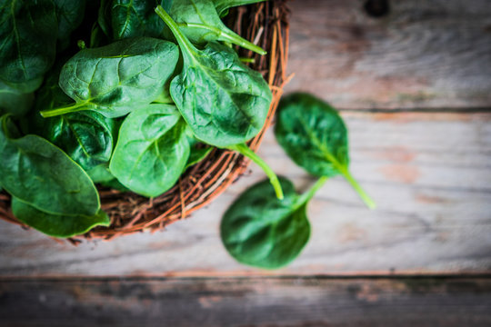 Fresh spinach on rustic wooden background