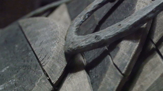 One black horshoe on the wood. This horshoe is placed on top of a wooden table 
