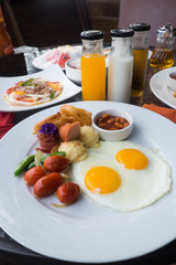 American breakfast with fried eggs, bacon, sausage  and juice