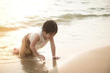 Cute asian boy playing on the beach