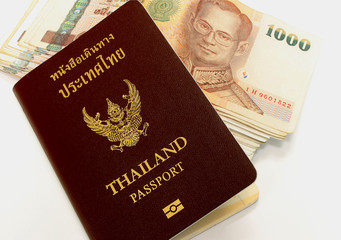 Thailand passport with Thai money on white background