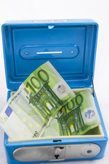 Billetes y monedas apilados de euro en una hucha