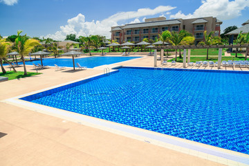 Fototapeta na wymiar Cayo Coco island, Melia jardines del rey,Cuba, Sep 2, 2015 amazing inviting gorgeous view of swimming pool, tranquil turquoise azure water and tropical garden against pretty blue sky background