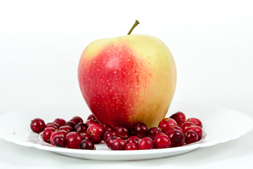 Красно-зеленые яблоки в корзинке на белом фоне на тарелке