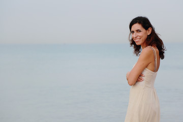 Fototapeta na wymiar beautiful 35 years old woman standing on the shore of the beach