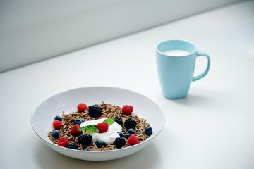 Breakfast with glass of mik and integral musli with berries mix