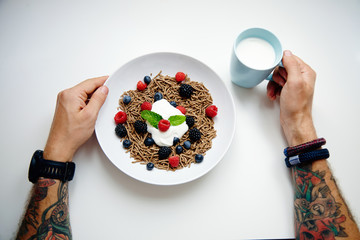 top view two tattooed hands and plate with integral musli with b