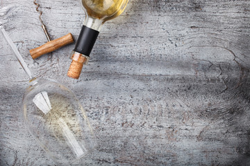 Bottle of white wine,a corkscrew,a glass,on wooden background.Copy space. selective focus.