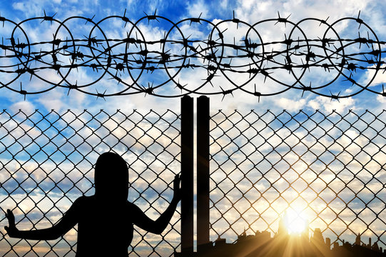  Silhouette of a refugee near the fence