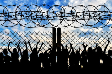 Silhouette of refugees and barbed wire