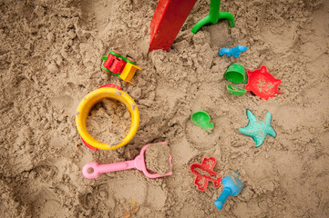 Bright plastic children toys in sandpit or on a beach