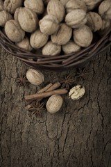 walnuts cinnamon and anise in a basket on cork board
