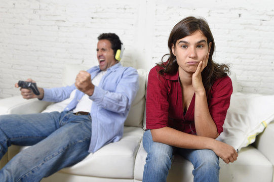 woman  angry and upset while husband or boyfriend plays videogames ignoring her
