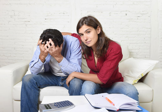 young couple worried home in stress wife comforting husband accounting debt unpaid  bills bank papers expenses