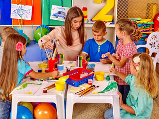 Group children with teacher in  preschool  kindergarten .