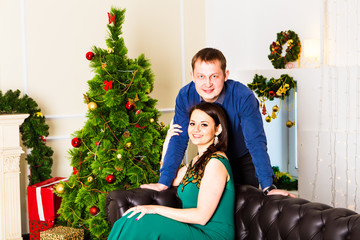 Obraz na płótnie Canvas Young happy couple near a Christmas tree