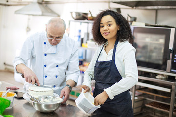 young girl learns to bake cakes with porfessionalnym baker