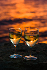 Two wine glasses on the background of sunset seascape