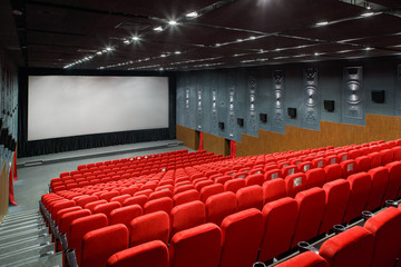 interior of a large room with a lot of theater red armchair and