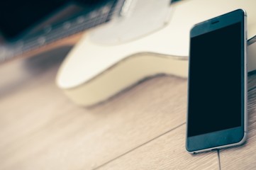 Man using mobile device and guitar