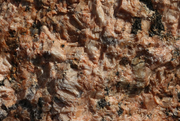 Broken stone rough surface close-up. The sharp eggs of crystals. Yellow-orange pattern with different natural  inclusions.