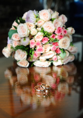 Obraz na płótnie Canvas wedding rings on a background of the bride's bouquet