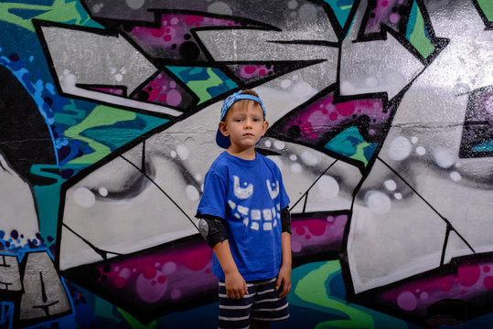 Trendy young boy in front of colorful graffiti