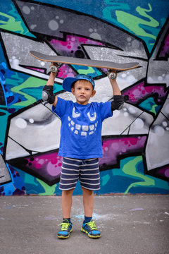 Cute little boy balancing a skateboard on his head