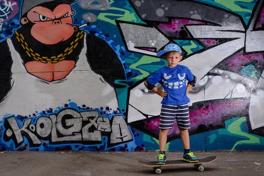 Handsome little boy holding his skateboard
