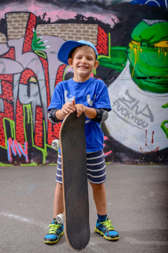 Happy young boy posing with his skateboard