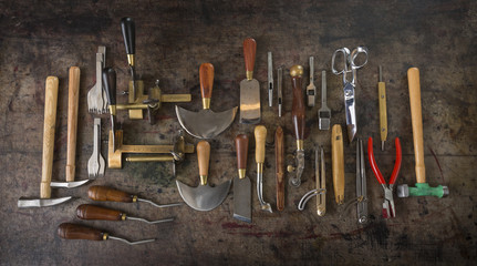 Leather goods craftsman's tools on a dirty work bench