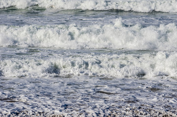 White surf moving ashore on a beach