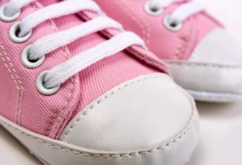 Pink baby girl shoes on a wooden floor outdoors