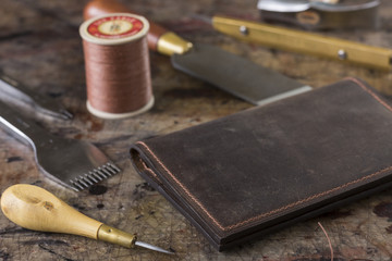 Leather goods craftsman's tools on a dirty work bench