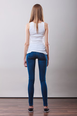 Girl full length in denim trousers white blank top rear view