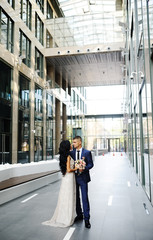 the bride and groom on the background of glass building