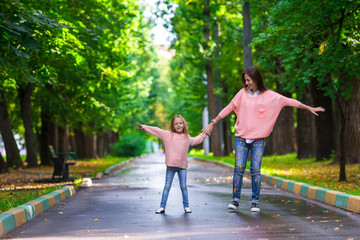 Happy mother and adorable little girl enjoying warm weather at