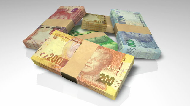 An extreme closeup pan around of a scattered pile of bundled increments of south african rand bank notes on an isolated background