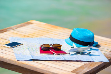 Closeup of passports, toy airplane, sunglasses on the map