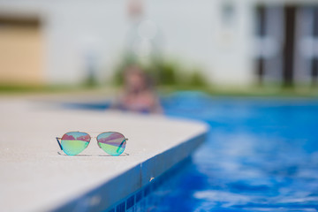 Fototapeta na wymiar Sunglasses near the swimming pool