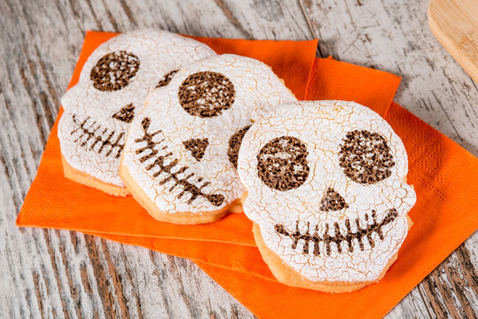 Halloween biscotti a forma di teschio farciti su tovaglioli di carta arancione