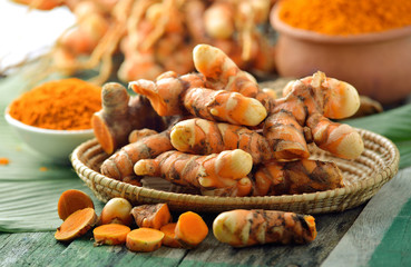 fresh turmeric roots in the basket on wooden table