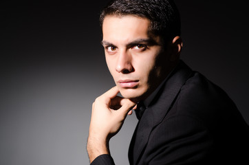 Young businessman in dark studio