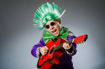 Fototapeta premium Funny man playing guitar in musical concept
