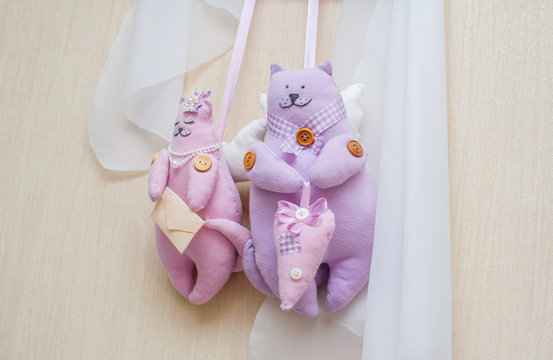 home-made rag dolls of cat hanging on the wall