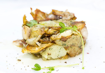 fried potatoes with bacon on a white plate