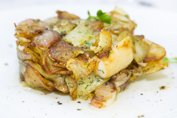 fried potatoes with bacon on a white plate