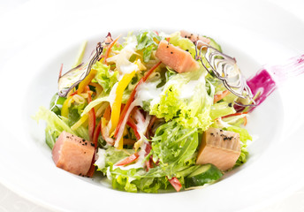 pink salmon salad and vegetables on a table in a restaurant