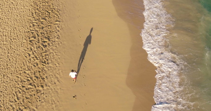 Aerial Shot of Young Man Running on Beach