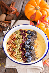 Pumpkin smoothie bowl with chia seeds, pecans, cranberries